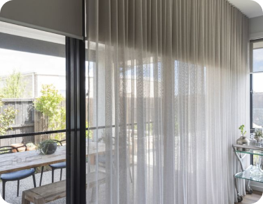 Light sheer curtains hang with soft folds, filtering gentle daylight.